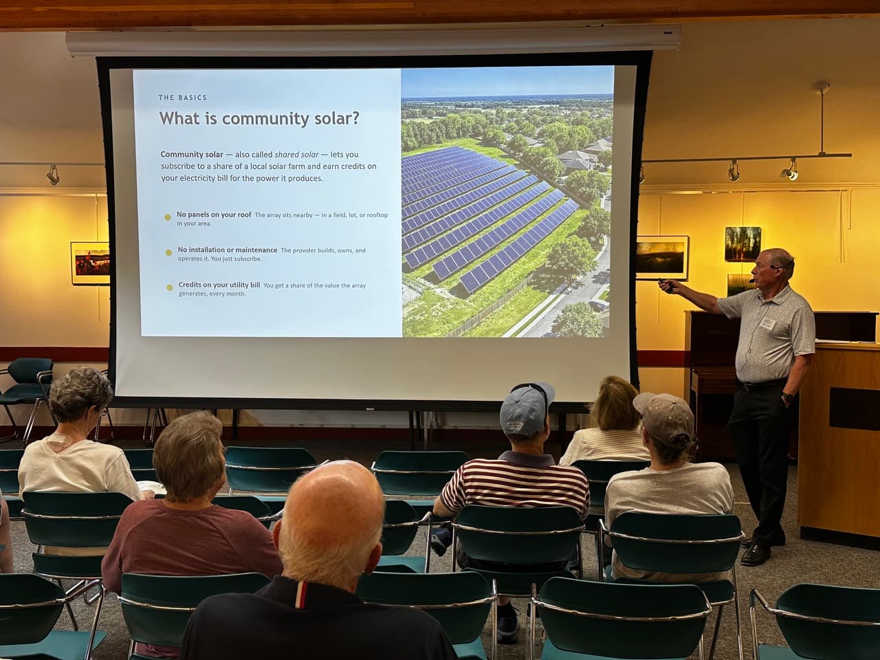 John Londa presenting a "What is community solar?" slide to the audience at Snow Library